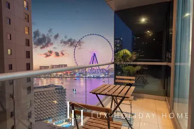 a view of a ferris wheel from a balcony at LUX The Luxury Sunny JBR Beach Views 2 in Dubai