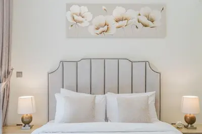 a bedroom with a white bed with white pillows at RH- Elegant & Cozy 1BR , Prime Location , Walk to Metro Station in Dubai