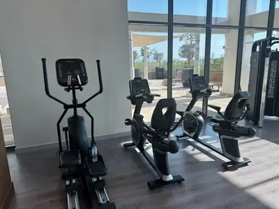 a row of exercise bikes in a fitness room at Cosy studio Free Parking Free unlimited drinkable water Near Downtown in Dubai