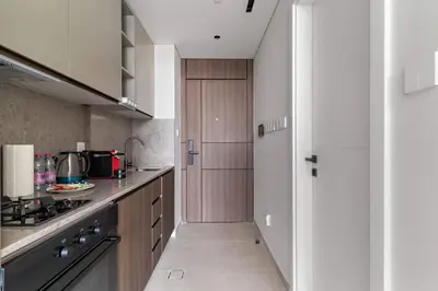 a kitchen with a refrigerator and a counter top at Chic Studio in Arjan with Gym Pool Free parking in Dubai