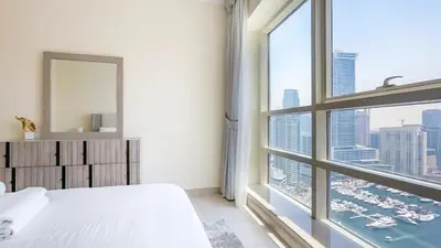 a bedroom with a large window with a view of a city at Relaxing Marina View Stay, Walk to Beach & Mall - 27AB02 in Dubai