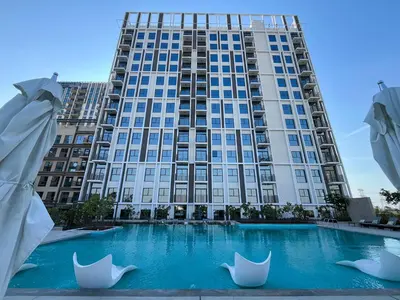 a large building with a swimming pool in front of it at Chic 1BR in Socio Dubai Hills Near Park and Mall in Dubai