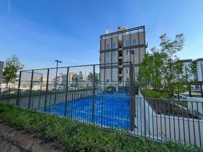 a fence with a pool in front of a building at Chic 1BR in Socio Dubai Hills Near Park and Mall in Dubai