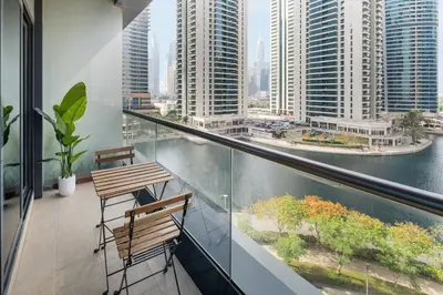 a balcony with two chairs and a view of a city at Urban Studio Apartment in Goldcrest Views JLT in Dubai