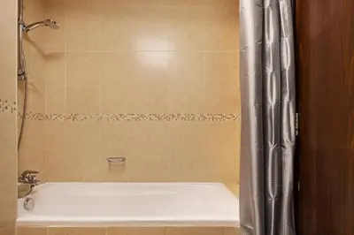 a bathroom with a bath tub with a shower curtain at Urban Studio Apartment in Goldcrest Views JLT in Dubai