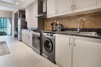 a kitchen with a sink and a dishwasher at Urban Studio Apartment in Goldcrest Views JLT in Dubai