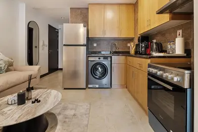 a kitchen with a refrigerator and a dishwasher at Luxury JLT Studio Lake View Metro Pool Access in Dubai