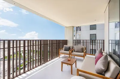 a living room with a balcony with a couch and chairs at Premium Home in Creek Beach with Lagoon Access in Dubai