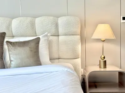 a bedroom with a white bed with a large headboard at Venduras- Chic 1BR Getaway near Burj Khalifa in Dubai