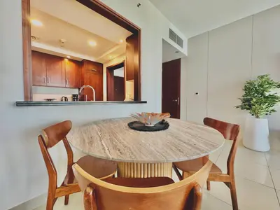 a dining room with a table and chairs and a kitchen at Venduras- Chic 1BR Getaway near Burj Khalifa in Dubai