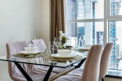 a dining room table with chairs and a window at Chic Marina Arcade Apartment Minutes to Beach in Dubai