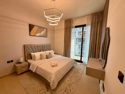 a bedroom with a bed with two wedding rings on it at Smart & Stylish 1BHK With Keyless Entry! in Dubai
