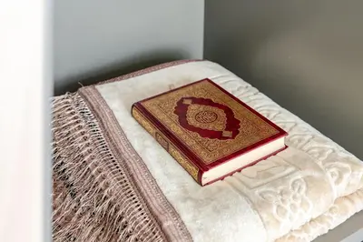 a book is sitting on top of a pillow at Cozy studio Pet Friendly Pool, Gym, Water Near Downtown in Dubai