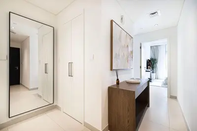 a hallway with a mirror and a wooden dresser at Mahogany 11 - 2BR 10 Guests - Walk to Burj Khalif in Dubai