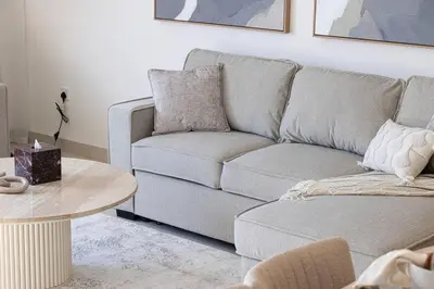 a living room with a couch and a table at Mahogany 11 - 2BR 10 Guests - Walk to Burj Khalif in Dubai