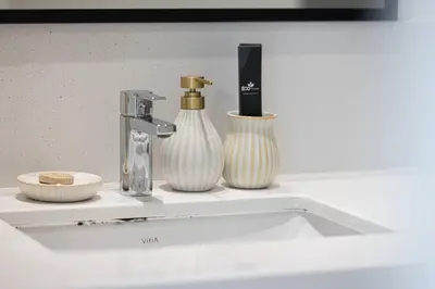 a bathroom sink with two vases on a shelf at Mahogany 11 - 2BR 10 Guests - Walk to Burj Khalif in Dubai