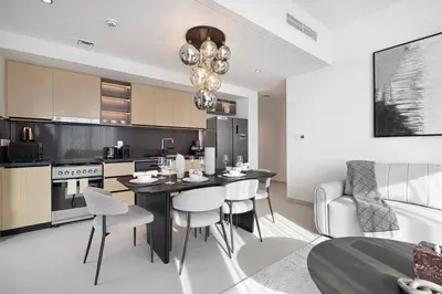 a kitchen and living room with a table and chairs at Mahogany 12 - 2BR 10 Guests - Walk to Burj Khalifa in Dubai