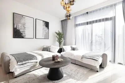 a living room with two beds and a table at Mahogany 12 - 2BR 10 Guests - Walk to Burj Khalifa in Dubai