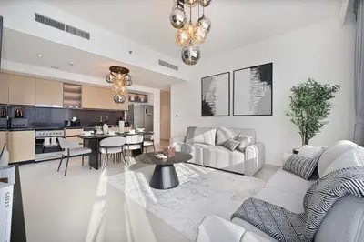 a living room and kitchen with a couch and a table at Mahogany 12 - 2BR 10 Guests - Walk to Burj Khalifa in Dubai