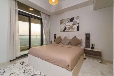 a bedroom with a large bed and a large window at Samani vacation homes 5210 ocean view in Dubai