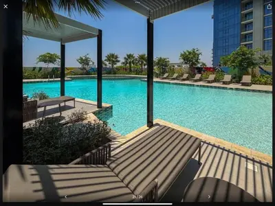 a large swimming pool with chairs and a building at Samani vacation homes 5210 ocean view in Dubai