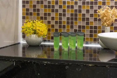 a counter with three vases and a sink and flowers at Nice 2 Bedroom Apartment! 5 Minutes walk to Dubai Mall, Downtown Dubai in Dubai