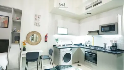 a kitchen with a sink and a dishwasher at Elevated Living Studio Facing the Burj in Dubai