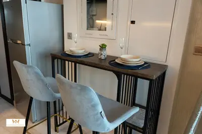 a small table with two chairs and a refrigerator at Elevated Living Studio Facing the Burj in Dubai