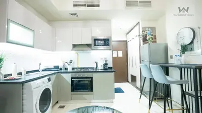 a kitchen with a washer and dryer at Elevated Living Studio Facing the Burj in Dubai