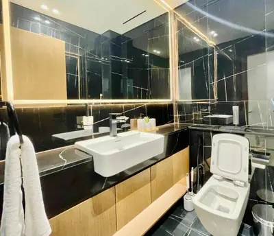 a bathroom with a white toilet and a sink at Opulent Nook 1br Designer Hideaway In Onyx in Dubai