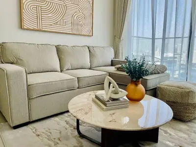 a living room with a couch and a coffee table at Opulent Nook 1br Designer Hideaway In Onyx in Dubai