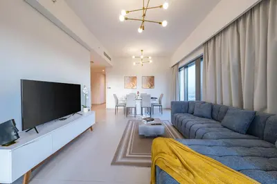 a living room with a blue couch and a flat screen tv at Downtown Dubai 3BR Burj Royale in Dubai