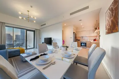 a dining room and living room with a table and chairs at Downtown Dubai 3BR Burj Royale in Dubai