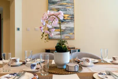 a table with a vase with pink flowers on it at Golden Mile at its Best 2BR Plus Maids Palm Jumeirah in Dubai