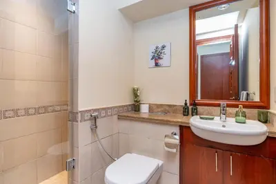 a bathroom with a sink and a toilet and a mirror at Golden Mile at its Best 2BR Plus Maids Palm Jumeirah in Dubai
