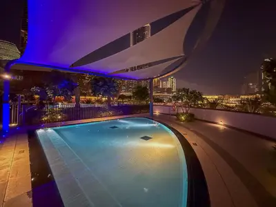 a swimming pool on top of a building at night at Sky-High Burj Khalifa and Fountain Views in Dubai