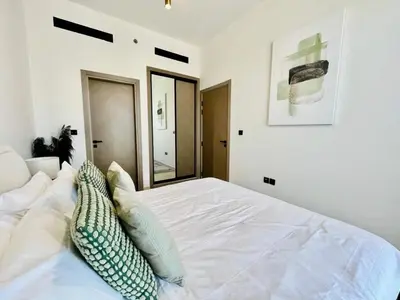 a bedroom with a white bed with a mirror at Comfortable 1br In Jvc Balcony Free Parking in Dubai