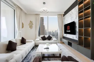 a living room with a white couch and a tv at Upgraded 3BR plus Maid's near Burj Khalifa & Dubai Opera in Dubai