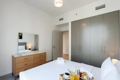 a bedroom with a bed with a plate of food on it at Upgraded 3BR plus Maid's near Burj Khalifa & Dubai Opera in Dubai
