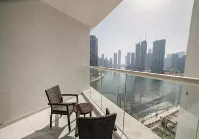 a balcony with two chairs and a view of the city at Stunning Canal View with Balcony in Dubai