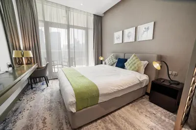 a bedroom with a bed and a desk and a window at Stunning Canal View with Balcony in Dubai