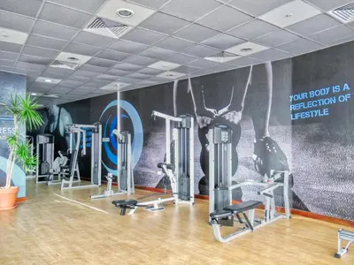 a gym with several tread machines and a mural at The Smart Concierge - Dorra Bay in Dubai