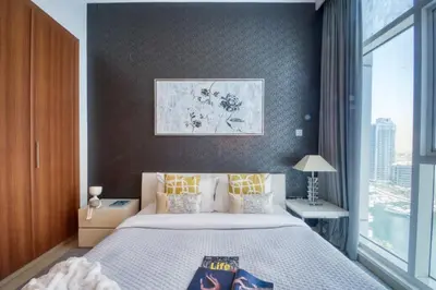a bedroom with a large bed and a window at The Smart Concierge - Dorra Bay in Dubai