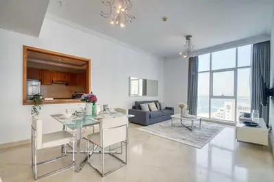 a kitchen and living room with a table and a couch at The Smart Concierge - Dorra Bay in Dubai