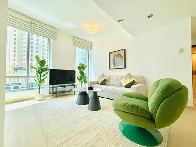 a living room with a couch and a large window at Vserve - 1 BR Escape in the Heart of Dubai Marina in Dubai