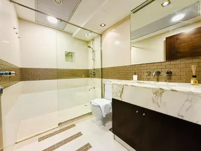 a bathroom with a sink and a shower and a toilet at Vserve - 1 BR Escape in the Heart of Dubai Marina in Dubai