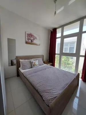 a bedroom with a bed and a large window at Damac Hills 2- Relaxing 3BR townhouse - Homeyvillas in Dubai