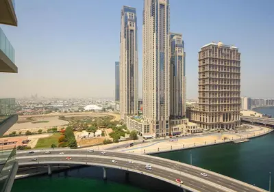 a bridge over a river in a city with tall buildings at Luxury 2BR in Urban Oasis by Missoni on High Floor in Dubai