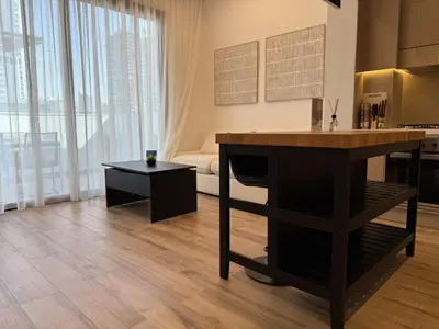 a kitchen with a counter and a table in a room at Vserve - Peaceful 1 BR Getaway in Vibrant JVC in Dubai