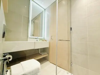 a bathroom with a shower and a sink and a mirror at Vserve - Peaceful 1 BR Getaway in Vibrant JVC in Dubai